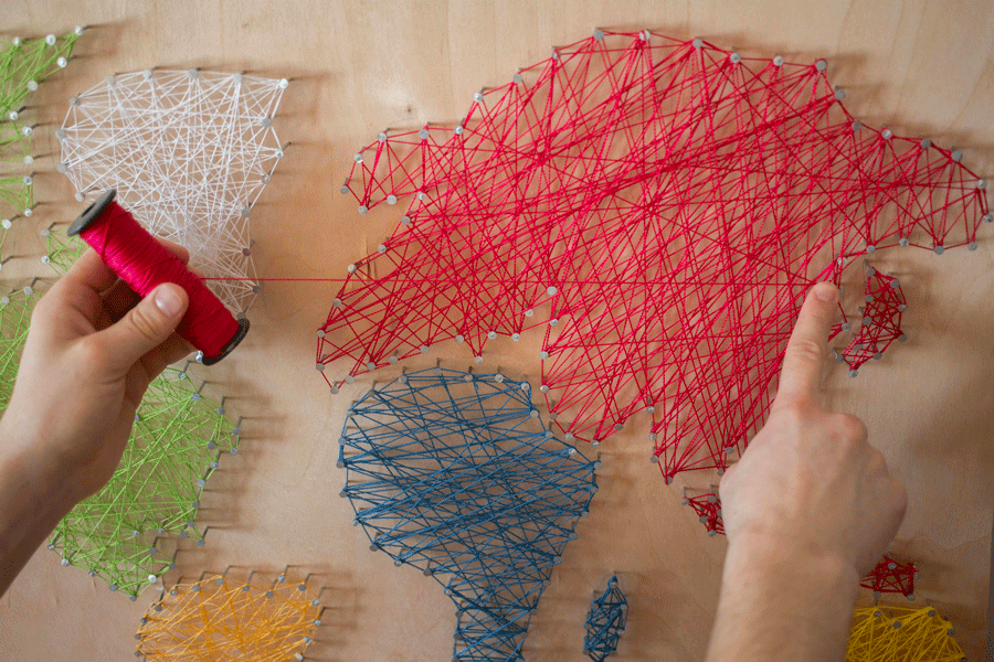 Matériel pour faire du String Art avec planche de bois, clous, marteau et fils colorés